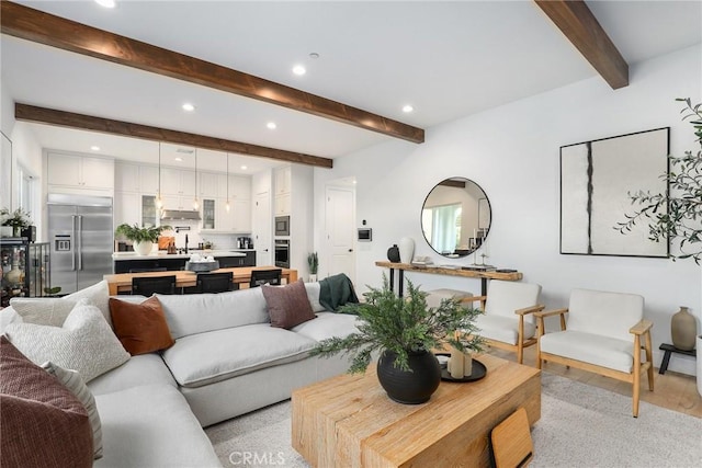 living area with light wood-type flooring, recessed lighting, and beamed ceiling