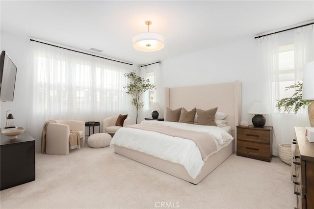 bedroom featuring visible vents and light colored carpet