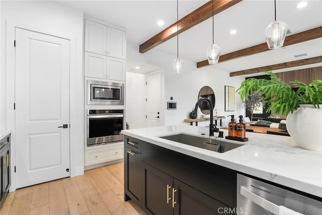 kitchen featuring stainless steel appliances, white cabinetry, and pendant lighting