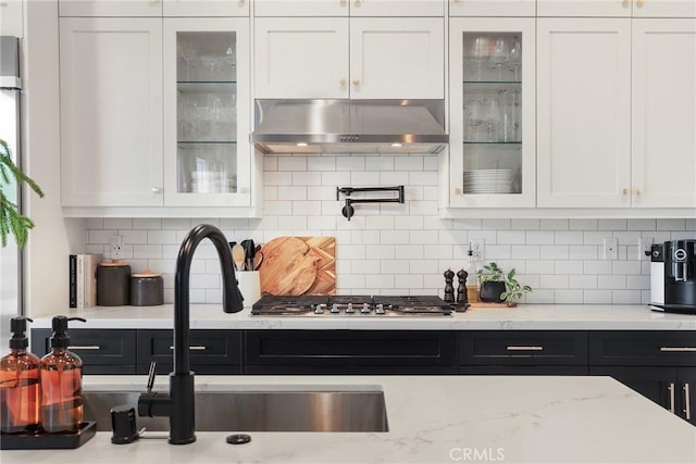 kitchen with white cabinetry, glass insert cabinets, and ventilation hood