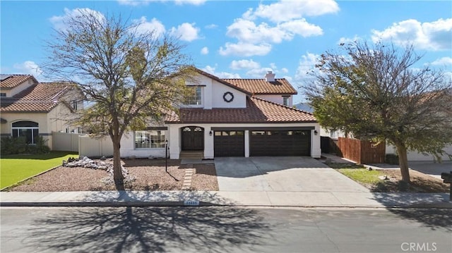 mediterranean / spanish home featuring a garage, a tile roof, fence, driveway, and a chimney