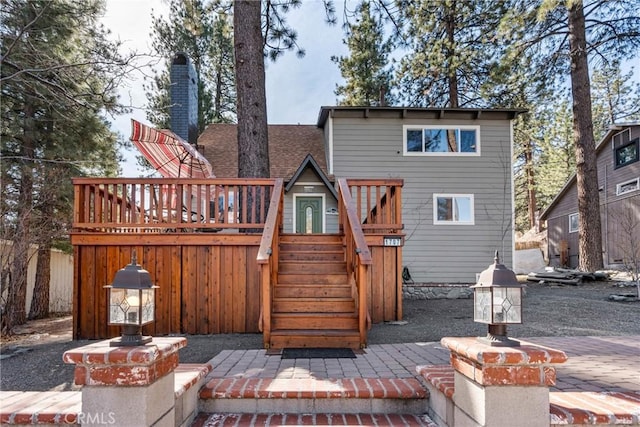 1707 Twin Lakes Dr, Wrightwood, CA 92397 - back of property featuring a wooden deck, stairway, a chimney, and a patio area