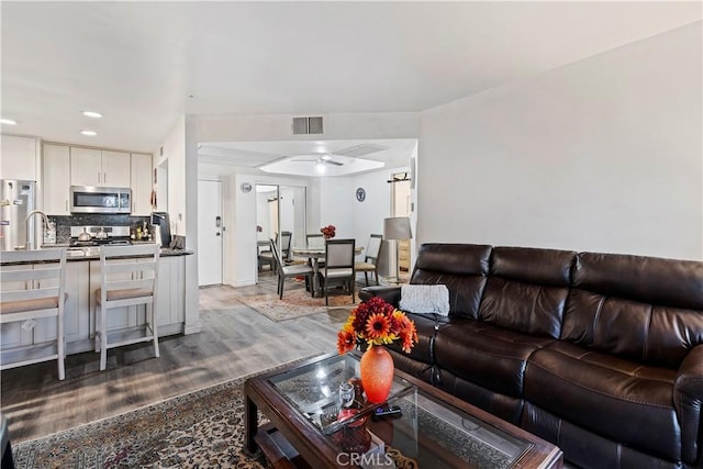 living room with ceiling fan and wood-type flooring