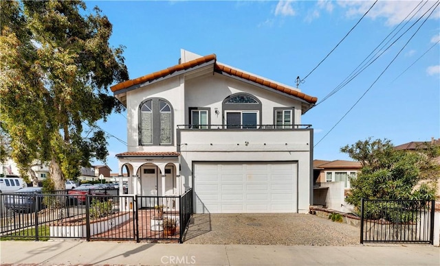 mediterranean / spanish home featuring an attached garage, a gate, a fenced front yard, stucco siding, and concrete driveway