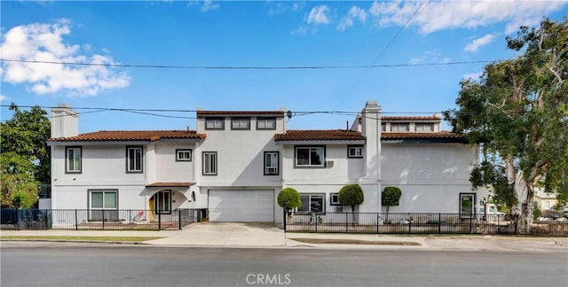 mediterranean / spanish-style house featuring stucco siding, a fenced front yard, an attached garage, a chimney, and concrete driveway