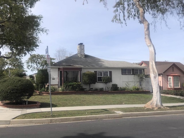 ranch-style house with a front yard and stucco siding