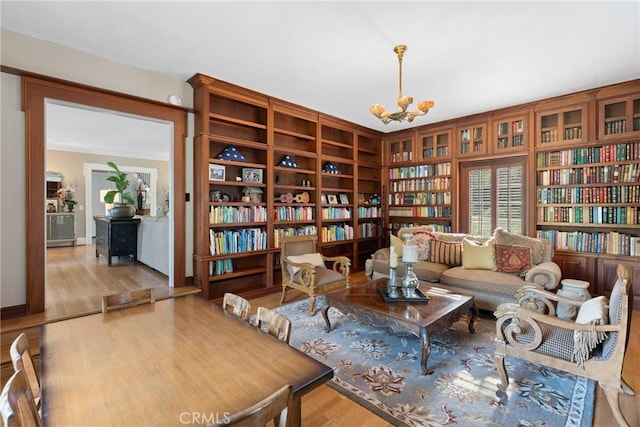 1205 W Highland Ave, Redlands, CA 92373 - living area with a chandelier, wood finished floors, and wall of books