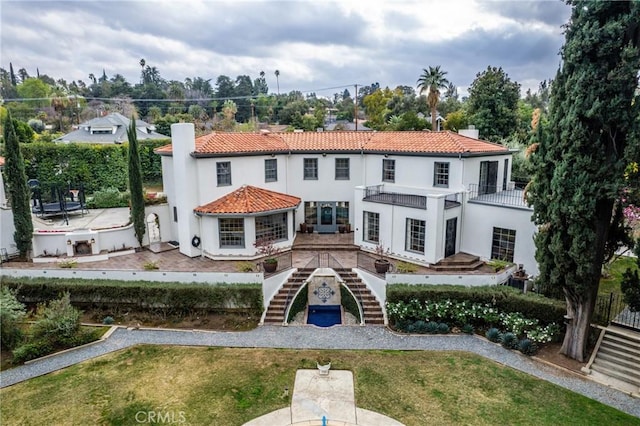 1205 W Highland Ave, Redlands, CA 92373 - rear view of house with stairs, a tile roof, a chimney, and a lawn