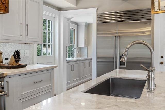 1205 W Highland Ave, Redlands, CA 92373 - kitchen with a sink, tasteful backsplash, built in refrigerator, and light stone countertops