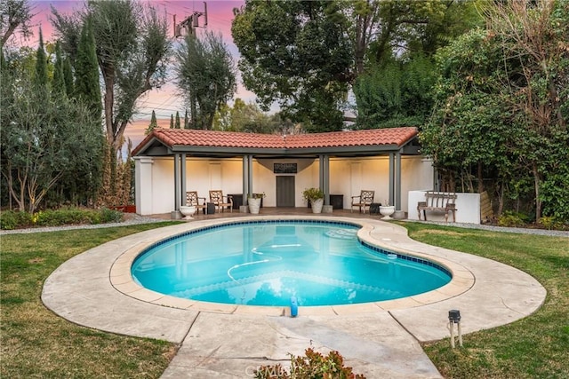 1205 W Highland Ave, Redlands, CA 92373 - pool at dusk featuring a patio, an outdoor pool, and a lawn