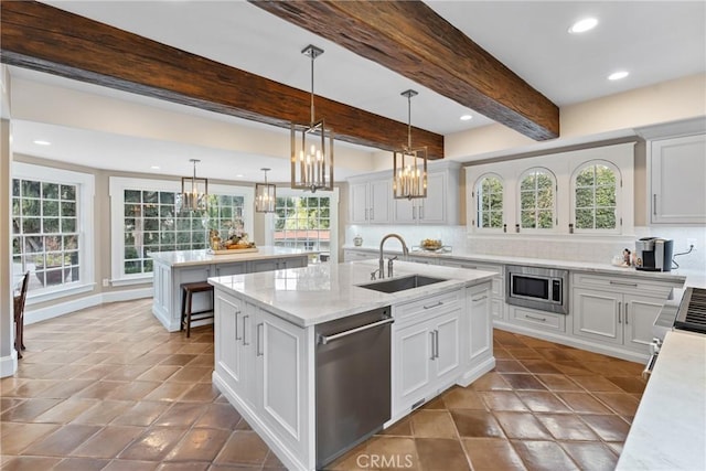1205 W Highland Ave, Redlands, CA 92373 - kitchen with stainless steel appliances, a sink, an island with sink, a chandelier, and tasteful backsplash