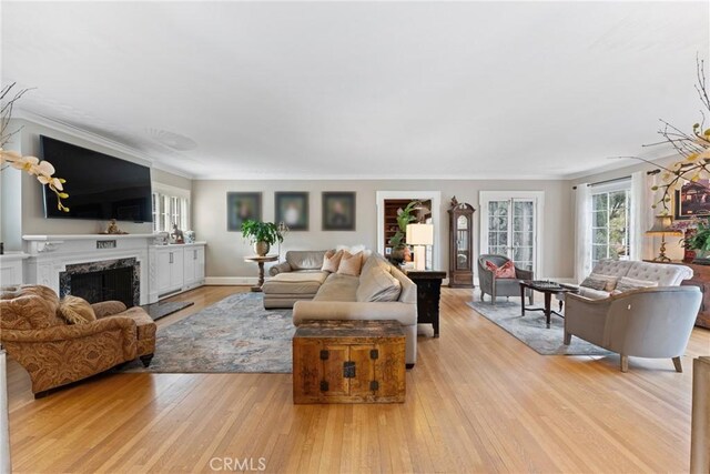 1205 W Highland Ave, Redlands, CA 92373 - living area with plenty of natural light, a high end fireplace, light wood finished floors, and crown molding