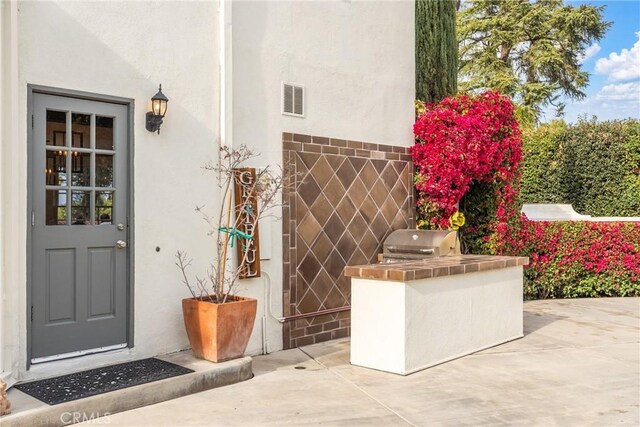 1205 W Highland Ave, Redlands, CA 92373 - view of exterior entry with exterior kitchen, stucco siding, and a patio area
