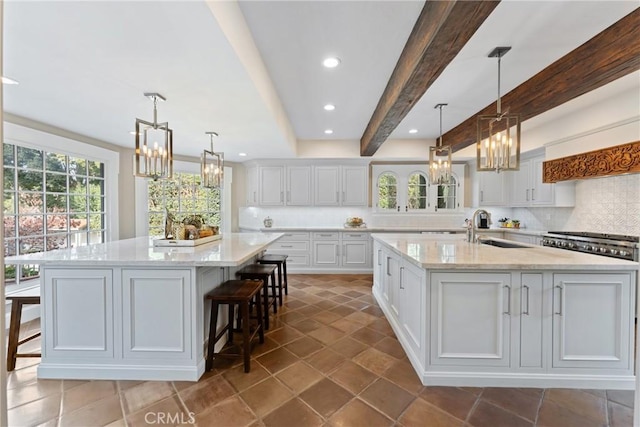 1205 W Highland Ave, Redlands, CA 92373 - kitchen with a large island with sink, a chandelier, a sink, backsplash, and recessed lighting