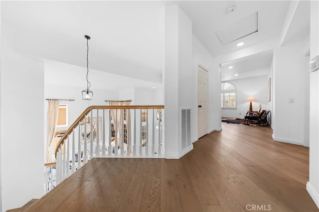 corridor with recessed lighting, visible vents, an upstairs landing, wood finished floors, and baseboards