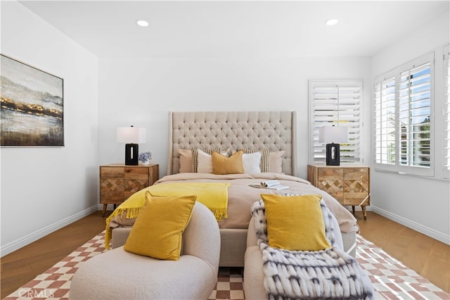 bedroom with baseboards, wood finished floors, and recessed lighting