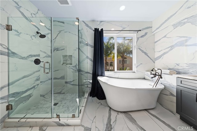 full bathroom with a marble finish shower, a soaking tub, marble finish floor, vanity, and stone wall