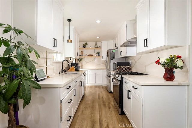 kitchen featuring appliances with stainless steel finishes, hanging light fixtures, and white cabinetry