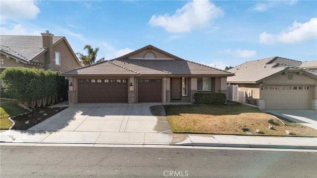 view of front of home with stucco siding, concrete driveway, an attached garage, a tiled roof, and a front lawn