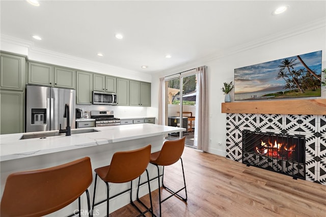 kitchen with crown molding, appliances with stainless steel finishes, and green cabinetry