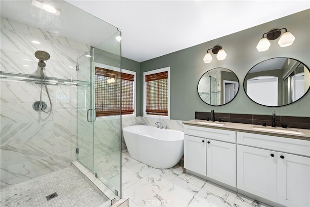 bathroom featuring a soaking tub, a stall shower, marble finish floor, and a sink