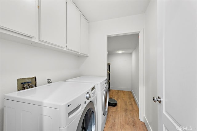 laundry room with light wood-style flooring, independent washer and dryer, cabinet space, and baseboards