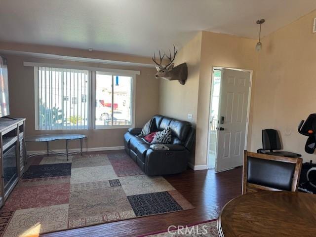 living area featuring dark wood-type flooring and baseboards