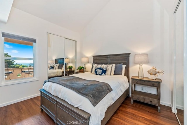 bedroom featuring dark wood-style floors, baseboards, vaulted ceiling, and a closet