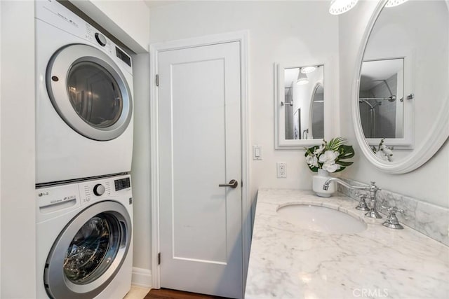 washroom with a sink, laundry area, and stacked washer / drying machine