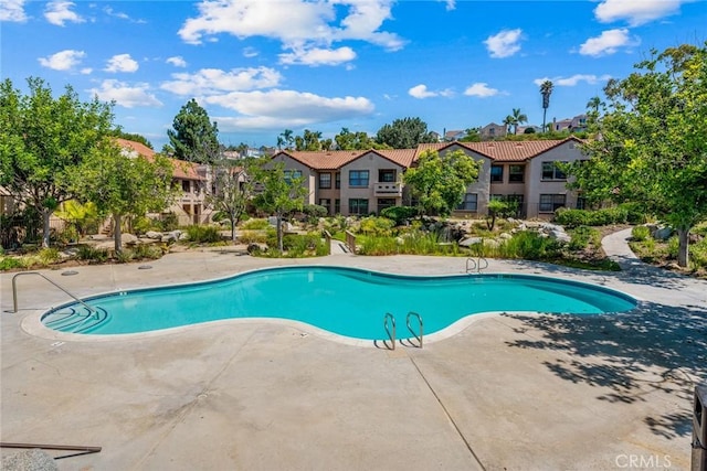 outdoor pool featuring a residential view and a patio