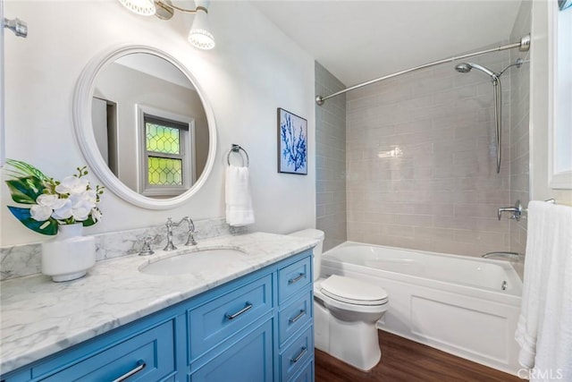 bathroom with toilet, shower / bath combination, wood finished floors, and vanity