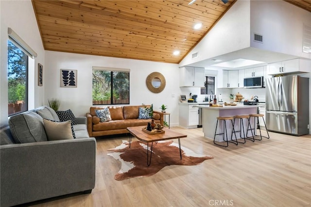 living room with high vaulted ceiling, light wood-type flooring, a wealth of natural light, and wooden ceiling