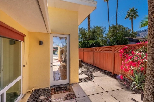 exterior space with a patio area, fence, and stucco siding