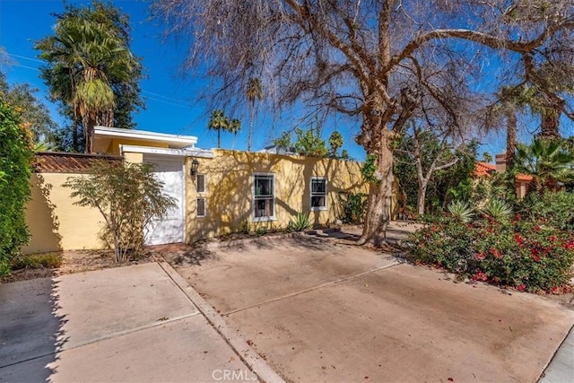 view of front of home with fence and stucco siding