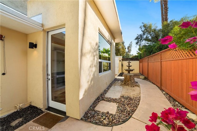 view of side of property with fence and stucco siding