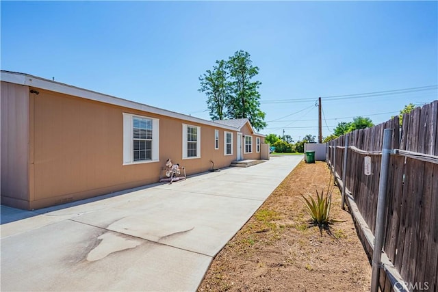 view of side of property with a patio area and fence