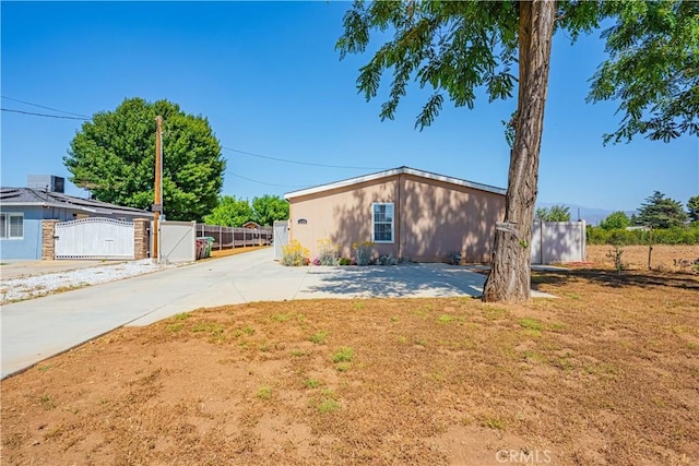 view of front of property with a gate, fence, driveway, and a front lawn