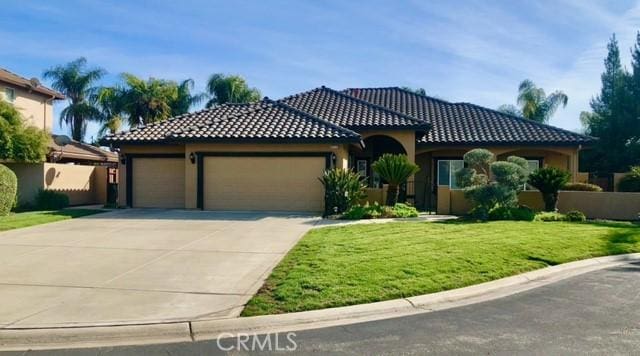 mediterranean / spanish-style house featuring a front yard and a garage