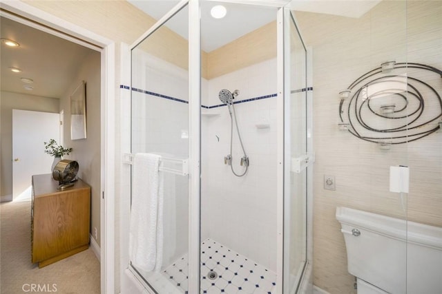 bathroom featuring toilet, tile walls, and walk in shower