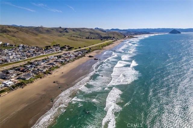 drone / aerial view featuring a water and mountain view and a view of the beach