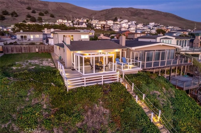 back house at dusk with a patio and a mountain view