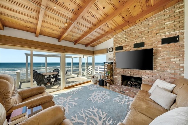 living room with a view of the beach, a brick fireplace, vaulted ceiling with beams, and wood ceiling