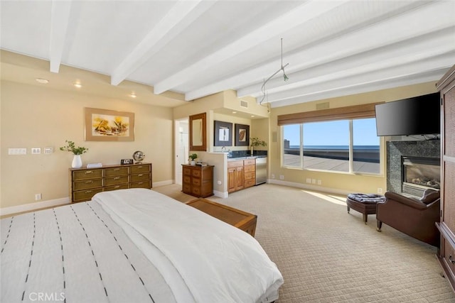 carpeted bedroom featuring beam ceiling and a fireplace