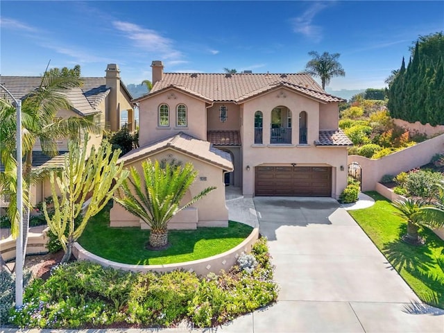 mediterranean / spanish-style home with an attached garage, a tile roof, fence, concrete driveway, and stucco siding