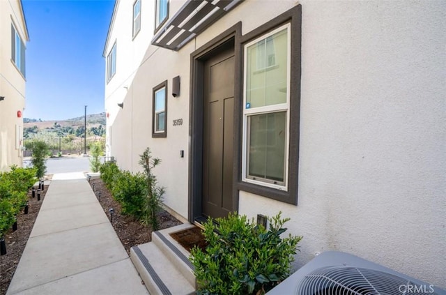 view of side of home featuring central AC and stucco siding