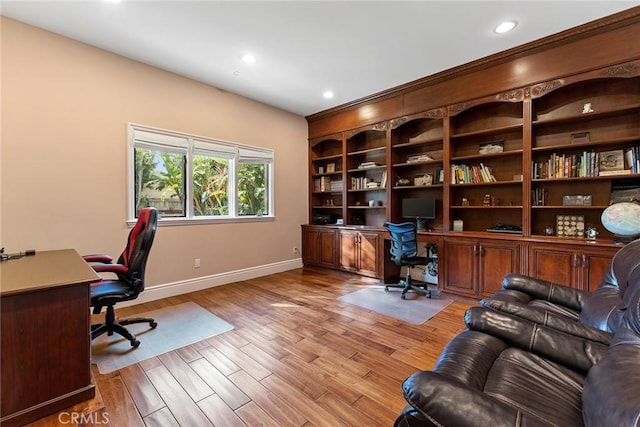 office space with light wood-type flooring and built in desk