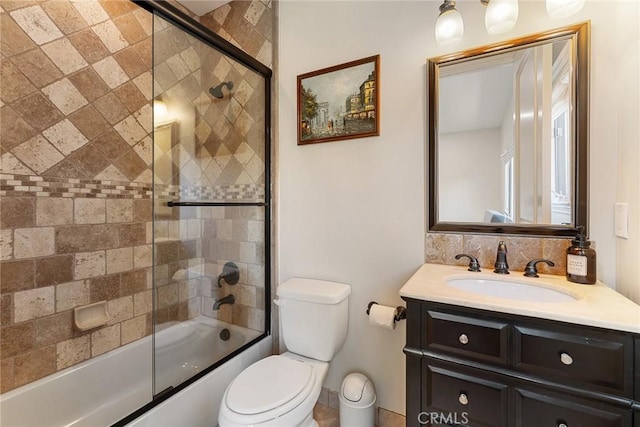 full bathroom featuring combined bath / shower with glass door, vanity, toilet, and backsplash