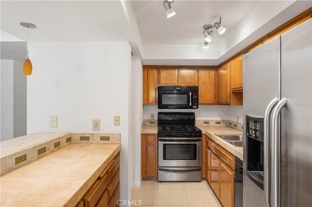 1150 E Palm Canyon Dr Unit 51, Palm Springs, CA 92264 - kitchen featuring stainless steel appliances, brown cabinets, light countertops, and light tile patterned floors