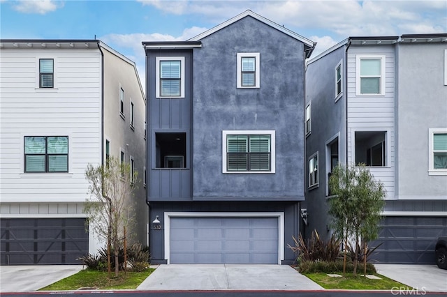 view of front facade featuring a garage, concrete driveway, and stucco siding