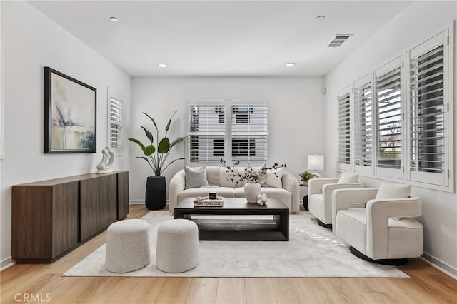 living area featuring recessed lighting, light wood-type flooring, visible vents, and baseboards